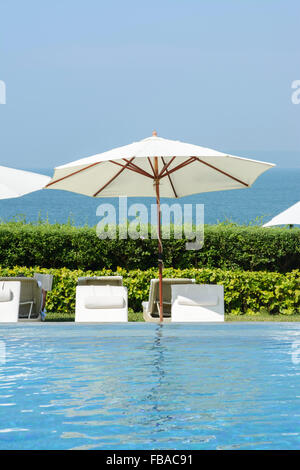 Liegestühle und Sonnenschirme am Pool in Goa, Indien, Asien Stockfoto