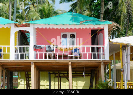 Bunte Strandhäuschen unter den Palmen am Strand von Palolem, in Goa, Indien Stockfoto