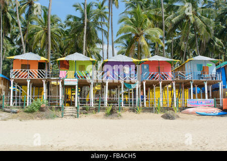 Bunte Strandhäuschen unter den Palmen am Strand von Palolem, in Goa, Indien Stockfoto