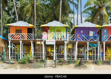 Bunte Strandhäuschen unter den Palmen am Strand von Palolem, in Goa, Indien Stockfoto