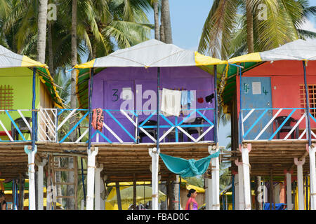 Bunte Strandhäuschen unter den Palmen am Strand von Palolem, in Goa, Indien Stockfoto