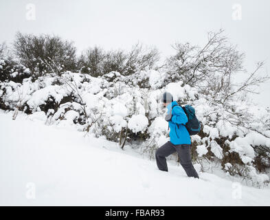 Männliche Wanderer in tiefem Schnee auf Ansatz zum roseberry Topping in North York Moors National Park, North Yorkshire, England. Großbritannien Stockfoto