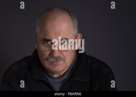 Porträt von ein nachdenklicher kaukasischen Mann vor einem dunklen Hintergrund Stockfoto
