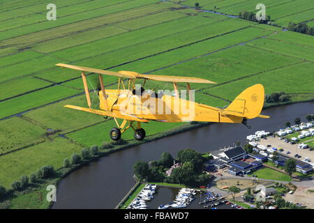 Eine de Havilland Tiger Moth Doppeldecker über die niederländische Landschaft Stockfoto