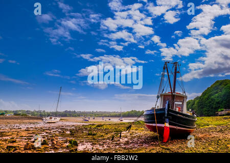 Ein Segelboot ruht auf den Rumpf bei Ebbe in Red Wharf Bay, Anglesey, Wales. Stockfoto