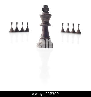 Schach. Schwarzer König, acht Bauern aus dem Fokus und ihre Schatten auf weißem Hintergrund. Leistung, Wettbewerb oder Leadership-Konzept Stockfoto