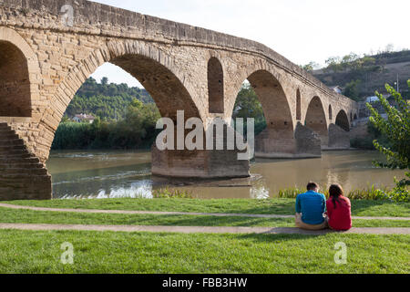 Paar, sitzen in der Nähe der mittelalterliches Brücke in Puente La Reina - Navarra, Spanien. Stockfoto