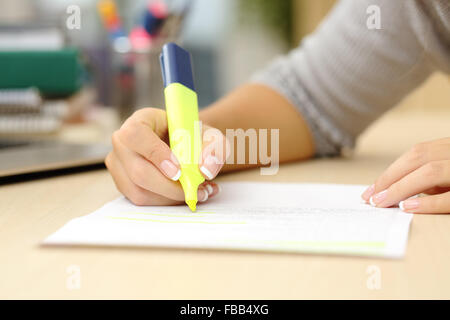 Nahaufnahme von einem Schüler Hand unterstreicht ein Dokument auf einem Schreibtisch zu Hause Stockfoto