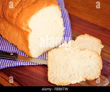 Laib Brot. Frisch aus dem Ofen heiß hausgemachte geschnittenem Brot auf einem rustikalen Land Hintergrund. Stockfoto