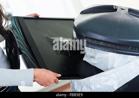 Defekten Computerbildschirm gehen in großen schwarzen Müll Müllcontainer. Stockfoto