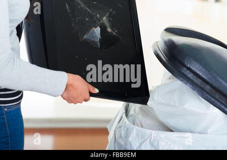 Defekten Computerbildschirm gehen in großen schwarzen Müll Müllcontainer. Stockfoto