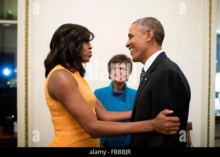 Washington DC, USA. 12. Januar 2016. US-Präsident Barack Obama wird von First Lady Michelle Obama und Senior Advisor Valerie Jarrett nach seinem endgültigen Zustand der Anschluß-Adresse in einer gemeinsamen Sitzung des Kongresses auf dem Capitol Hill 12. Januar 2016 in Washington, DC umarmte. Stockfoto