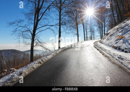 Leere Straße im Winter mit Sonne Strahl in den Himmel Stockfoto