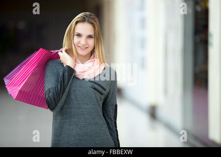 Lächelnd gut aussehende Teenager-Mädchen zum Einkaufen, Wandern im Supermarkt mit Papiertüten, Exemplar Stockfoto