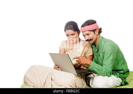 2 indische ländlichen verheiratet paar sitzt Charpai Laptop arbeiten Fingerzeig anzeigen Stockfoto