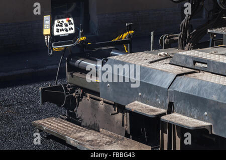 Städtische Straße im Bau, Asphaltierung im Gange. Fertiger Maschine Fragment mit Control panel Stockfoto