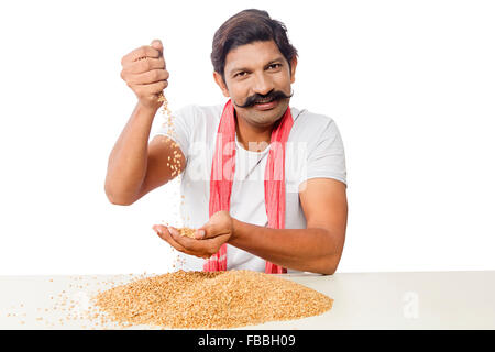 1 indische ländliche Landwirt Mann sitzen Korn Weizen-Qualitätsprüfung Stockfoto