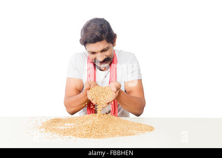 1 indische ländliche Landwirt Mann sitzen Korn Weizen-Qualitätsprüfung Stockfoto