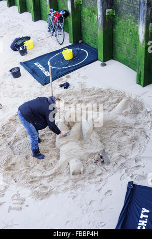 England, London, Southwark. Ein Bildhauer endet eine Sandskulptur am Ufer der Themse in der Nähe von Gabriels Wharf. Stockfoto