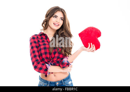 Schöne glückliche junge Frau mit langen lockigen Haaren hält rotes Herz in der hand über weißem Hintergrund stehen Stockfoto