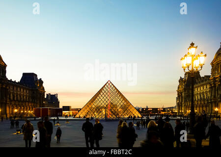 Louvre-Museum und Schloss mit Pyramide in Paris, Sonnenuntergang, Frankreich. Stockfoto