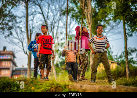 Nepalesische Kinder spielen auf einem traditionellen Bambus swing genannt Linge Ping. Flachen DOF. Stockfoto