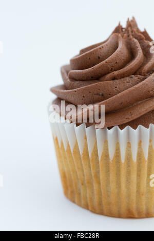 Eine Nahaufnahme Bild eines chocolate Cupcake mit Wirbelte die Glasur auf einem weißen Hintergrund. Stockfoto