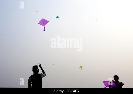 Dhaka, Dhaka, Bangladesh. 14. Januar 2016. 14. Januar 2016 - Dhaka, Bangladesch '' "alte Dhaka Gemeinschaft Menschen genießen posh Sankranti mit verschiedenen Aktivitäten, wie ein Mann Feuer am Abend am alten Dhaka bläst. Paush Shankranti "ist der letzte Tag des Bengali Monats Paush. Dieses traditionelle fest wird vor Ort bekannt als "˜Shakhrine". Schon flogen viele Kites am Himmel dahin. Verschiedene Farben und Größen. Die meisten von den Dächern dieser alten Gebäude waren besetzt mit Youngs (meistens) und einigen älteren. Bildnachweis: ZUMA Press, Inc./Alamy Live-Nachrichten Stockfoto