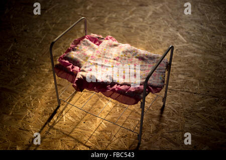 Niedliche kleine Spielzeug Bett im Morgenlicht mit Kissen und quilt Decke mit rosa Blume Ornament, Ansicht von oben Stockfoto