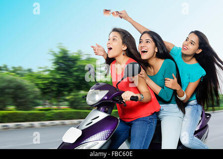 3 indische Junge Womans Freunde Straße Scooty Reiten Hand gestikulieren Stockfoto