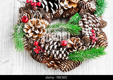 Festliche Weihnachtskranz mit Tanne und Kegel auf hölzernen Hintergrund Stockfoto