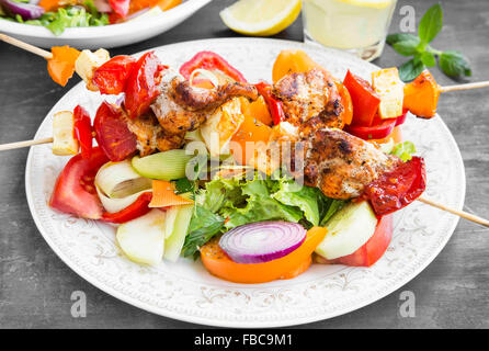 Spieße Essen mit gegrilltem Hähnchen, Tomaten, Paprika, Kürbisse und Gemüsesalate Stockfoto