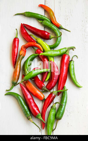 Rot, grün und Orange Hot Chili Peppers auf weißem Holz Hintergrund Stockfoto