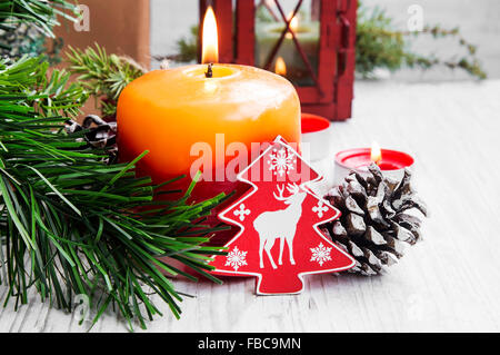 Weihnachts-Kerze-Dekoration mit Ornamenten und Tanne auf weiß lackiert Holz Stockfoto