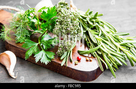 Kulinarische Kräuter Petersilie, Dill, Rosmarin und Thymian auf Holzbrett Stockfoto