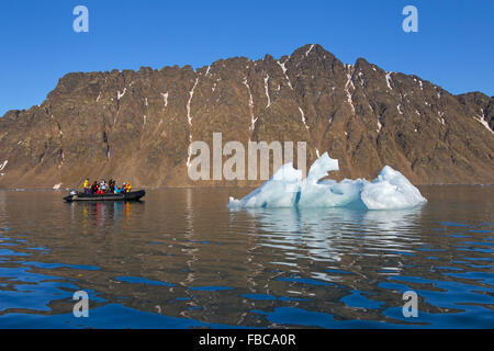 Öko-Touristen in Zodiac Boot fotografieren schmelzenden Eisberg im Lilliehöökfjorden Fjord in Krossfjorden, Spitzbergen, Svalbard Stockfoto