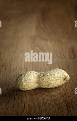 Ungeschälte Erdnüsse auf einem Holztisch Stockfoto