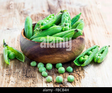 Frische Bio-Erbsen, grüne Gemüse auf hölzernen Hintergrund Stockfoto