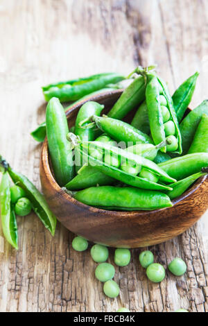Frische Bio-Erbsen, grüne Gemüse auf hölzernen Hintergrund Stockfoto