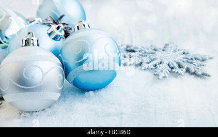 Silberne und blaue Weihnachtskugeln mit Funkeln Schneeflocken und Schnee Stockfoto