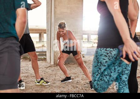 Schuss von junge Frau stretching nach einem Morgenlauf mit ihren Freunden. Club-Gruppe Pause vom laufen Training ausgeführt. Stockfoto