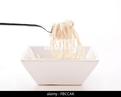 Spaghetti auf einer Gabel mit weißer Schale und Hintergrund Stockfoto