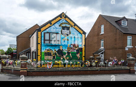 Eine irische GAA Hurling und Gaelic Fußball Wandbild in Märkten Belfast mit Blume Hommagen an die späten Jock Davison. Stockfoto