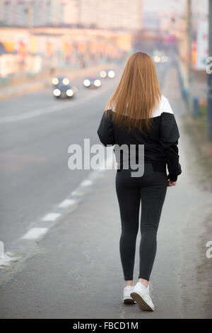 Schöne sportliche Mädchen mit langen Haaren tragen Läufer Sportbekleidung zu Fuß auf der Stadtbrücke, gesunden, aktiven Lebensstil-Konzept, ba Stockfoto