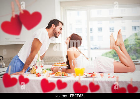 Zusammengesetztes Bild des jungen Paares mit einem romantischen Frühstück Stockfoto