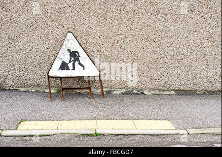 Eine rostige Warnzeichen für Baustellen, auf einem Bürgersteig in Schottland Stockfoto