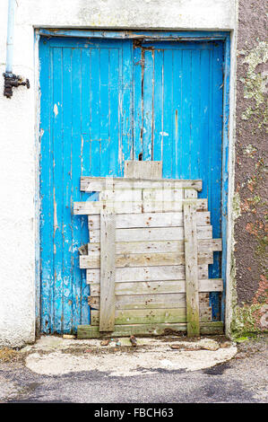 Eine blaue Tür, die von Brettern vernagelt Stockfoto