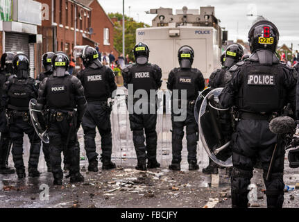 PSNI Aufruhr Polizisten Line-up hinter einer Wasserkanone auf Irish Republican Randalierer in Belfast verwendet wird Stockfoto