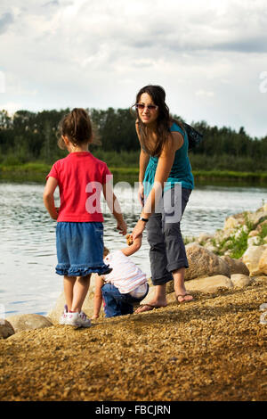 Junge Mutter und ihre zwei Kinder an einem See in Alberta, Kanada Stockfoto