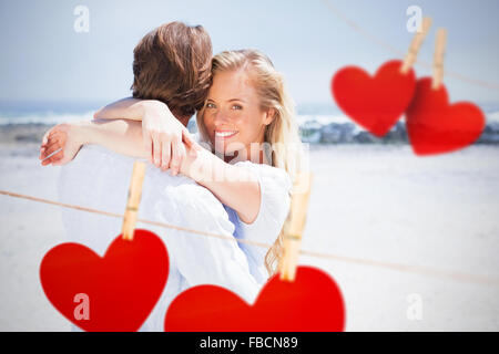 Zusammengesetztes Bild der umfassenden paar am Strand Stockfoto